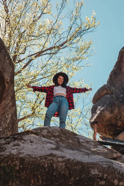 Mutlu kadın yürüyüşçü Kayanın tepesinde bahar zamanı