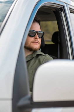 Sakallı adam yaz zamanı arabanın fotokopisini çekiyor.