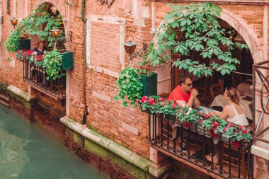 Venedik, İtalya - 25 Mayıs 2019: Grand Canal romantik tarihi yakınlarındaki kafede insanlar