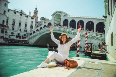 Venedik 'te rialto köprüsünün yanında oturan kadın gondollu Grand Canal' a bakıyor.