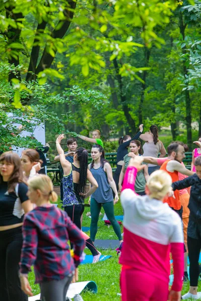 Lviv, Ukrayna - 2 Temmuz 2021: Şehir parkındaki birçok insan yoga yapıyor.