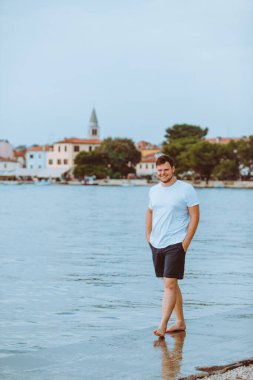 Hırvatistan 'da yaz akşamları deniz kıyısında gezen bir adam. tatil kavramı