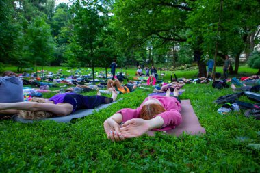 Lviv, Ukrayna - 2 Temmuz 2021: Şehir parkındaki birçok insan yoga yapıyor.