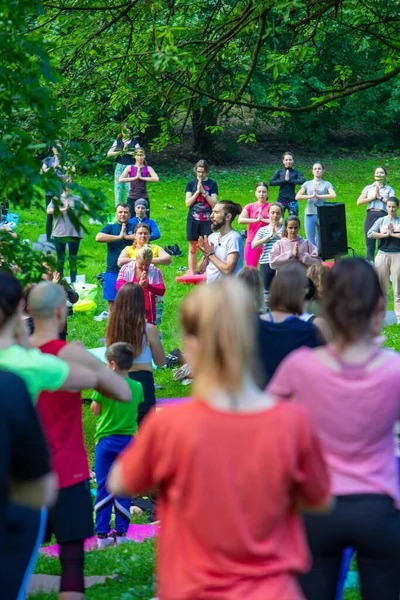Lviv, Ukrayna - 2 Temmuz 2021: Şehir parkındaki birçok insan yoga yapıyor.