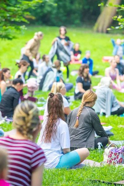 Lviv, Ukrayna - 2 Temmuz 2021: Şehir parkındaki birçok insan yoga yapıyor.