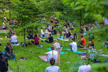 Lviv, Ukrayna - 2 Temmuz 2021: Şehir parkındaki birçok insan yoga yapıyor.