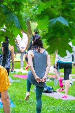 Lviv, Ukrayna - 2 Temmuz 2021: Şehir parkındaki birçok insan yoga yapıyor.