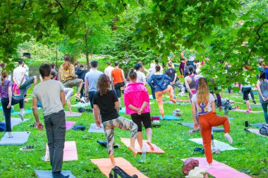 Lviv, Ukrayna - 2 Temmuz 2021: Şehir parkındaki birçok insan yoga yapıyor.