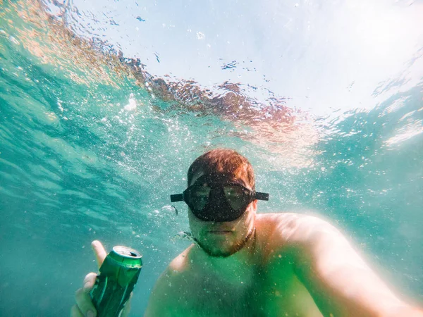 Man takes beer bottles from from bottom. sea pollution — Foto Stock