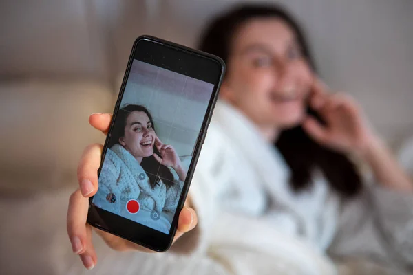 Young happy woman taking selfie story laying down in bed — Stock Photo, Image