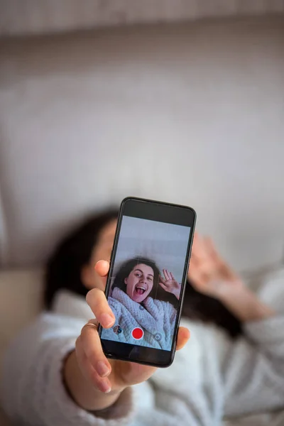 Young happy woman taking selfie story laying down in bed — Stock Photo, Image