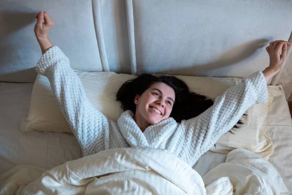 Morning in bed woman awaking laying down in bed with white sheets — Stock Photo, Image