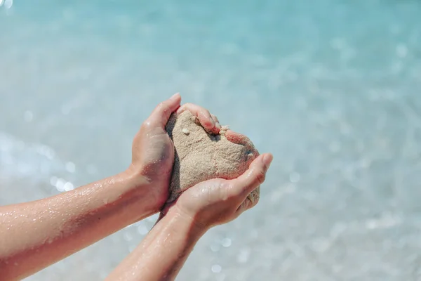 Женщина Держит Песок Делает Сердце Форму Морского Пляжа Заднем Плане — стоковое фото