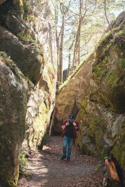 Sırt çantalı bir adam Ukrayna 'daki kanyon güvercini kayalarında yürüyor.