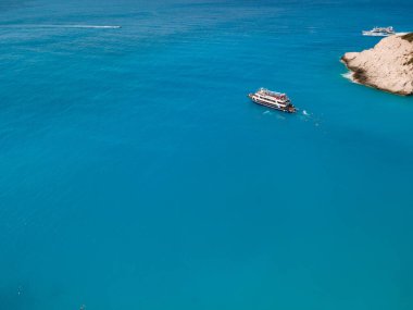 Porto Katsiki sahilinin havadan görünüşü yolcu teknesi insanlarıyla Yunanistan yaz tatilinde yüzerek atlarken eğleniyor.