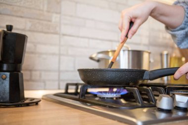 frying pan on cooking top blue flame close up