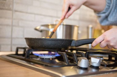 frying pan on cooking top blue flame close up