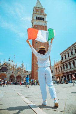 Venedik Meydanı Çan Kulesi 'nin ortasında İtalyan bayrağı taşıyan kadın yaz zamanı Campanile di San Marco