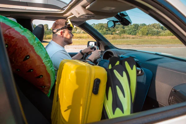 sea vacation car travel concept happy man in scuba mask driving car full of bags