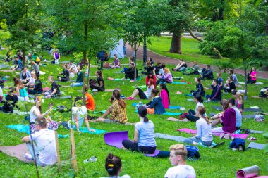 Lviv, Ukrayna - 2 Temmuz 2021: Şehir parkındaki birçok insan yoga yapıyor.