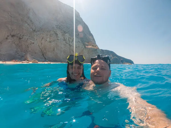 happy couple swimming in scuba mask underwater