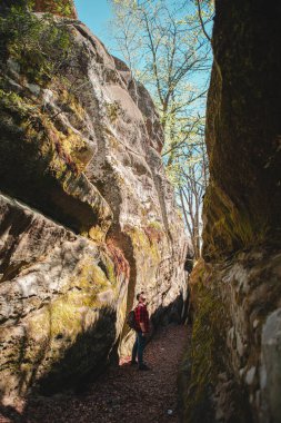 Sırt çantalı bir adam Ukrayna 'daki kanyon güvercini kayalarında yürüyor.