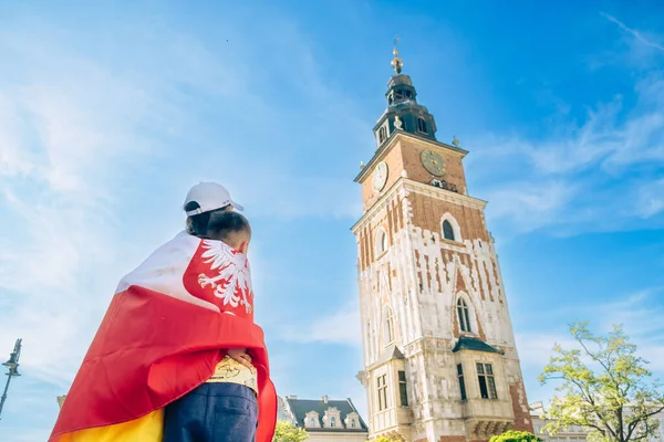 Annesi ve oğlu Polonya bayrağıyla kaplanmış Krakow çan kulesine bakıyor.