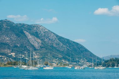 Lefkada adasında arka planda Yunanistan dağlarında yatları ve tekneleri olan deniz koyuna.