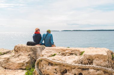 Pula, Hırvatistan - 21 Mayıs 2019: Deniz körfezi yaz tatilinin tadını çıkaran yaşlı çift