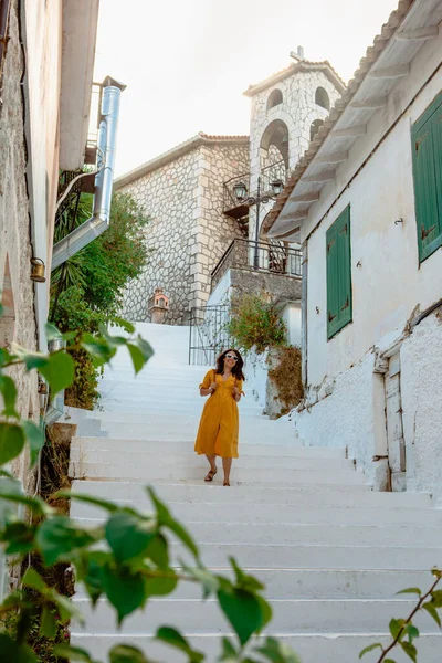 旅行やアクティブなライフスタイルの概念 若いです旅行者女性で黄色のドレス歩行で古いギリシャの町 — ストック写真