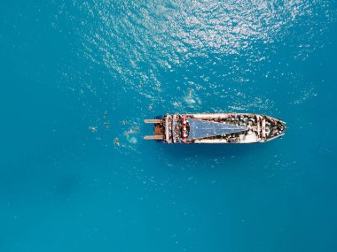 Porto Katsiki sahilinin havadan görünüşü yolcu teknesi insanlarıyla Yunanistan yaz tatilinde yüzerek atlarken eğleniyor.