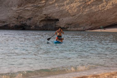 Lefkada, Yunanistan - 7 Eylül 2021: Köpek deniz tatili ile kürek çeken adam