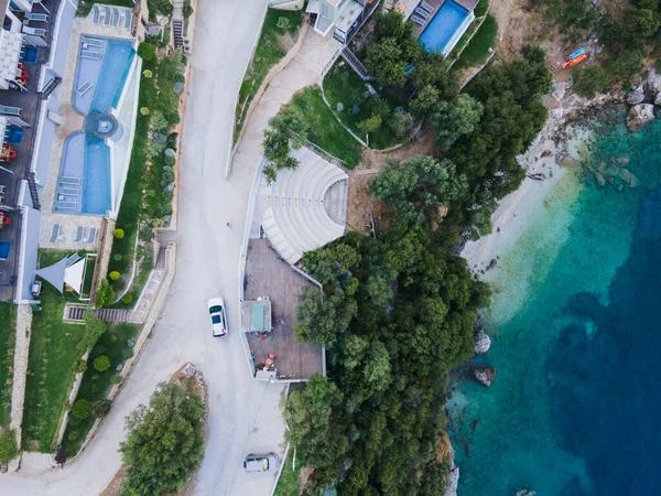 overhead view of car moving by road next to sea shore copy space