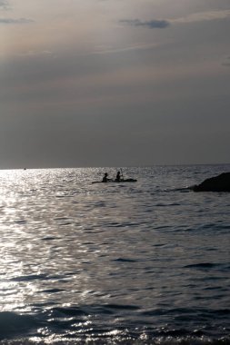 Gün batımında denizdeki kano silueti