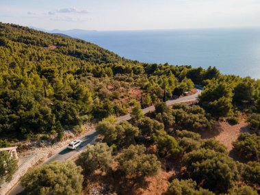 Yunanistan 'ın İyon Denizi yakınlarındaki Lefkada adasında karayoluyla hareket eden arabanın hava görüntüsü