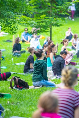 Lviv, Ukrayna - 2 Temmuz 2021: Şehir parkındaki birçok insan yoga yapıyor.