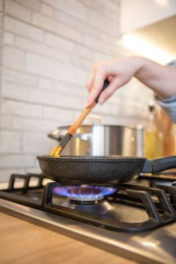 frying pan on cooking top blue flame close up