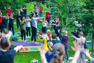 Lviv, Ukrayna - 2 Temmuz 2021: Şehir parkındaki birçok insan yoga yapıyor.