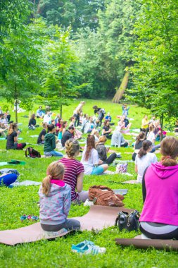 Lviv, Ukrayna - 2 Temmuz 2021: Şehir parkındaki birçok insan yoga yapıyor.