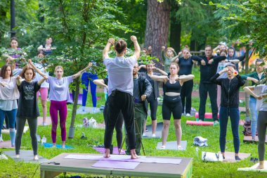 Lviv, Ukrayna - 2 Temmuz 2021: Şehir parkındaki birçok insan yoga yapıyor.