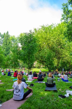 Lviv, Ukrayna - 2 Temmuz 2021: Şehir parkındaki birçok insan yoga yapıyor.