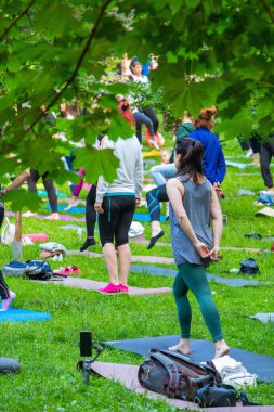 Lviv, Ukrayna - 2 Temmuz 2021: Şehir parkındaki birçok insan yoga yapıyor.