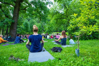 Lviv, Ukrayna - 2 Temmuz 2021: Şehir parkındaki birçok insan yoga yapıyor.