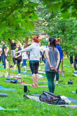 Lviv, Ukrayna - 2 Temmuz 2021: Şehir parkındaki birçok insan yoga yapıyor.