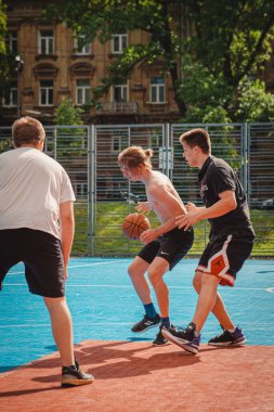 Lviv, Ukrayna - 28 Mayıs 2022: Erkekler açık havada güneşli bir yaz günü basketbol oynuyorlar
