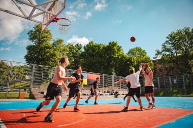 Lviv, Ukrayna - 28 Mayıs 2022: Erkekler açık havada güneşli bir yaz günü basketbol oynuyorlar