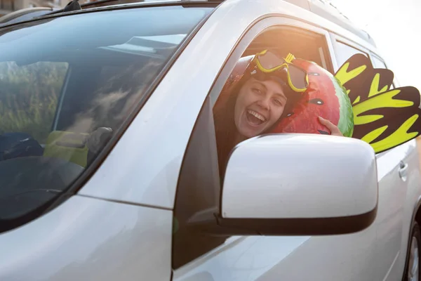 sea car travel trip smiling woman driver in car full of vacation stuff copy space