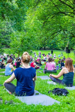 Lviv, Ukrayna - 2 Temmuz 2021: Şehir parkındaki birçok insan yoga yapıyor.
