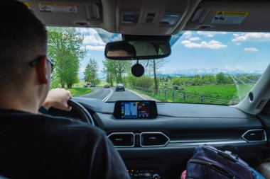 Adam araba kullanıyor. Dağlara giden yol.