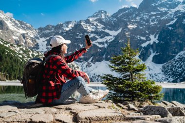 Gölün kıyısında bir kadın oturuyor. Morskie Oko, Tatras dağları. Polonya